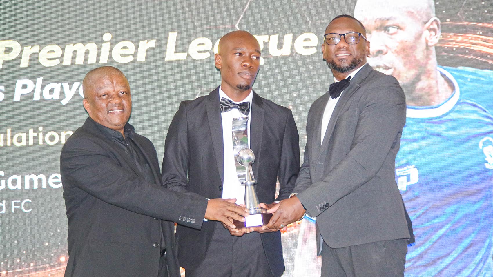 PLE CEO Pat ‘Kungumusa’ Vilakati (L) and MTN Fintech Head of Channel & Commercial MoMo Jordy Shiba, awarding the shining star of the night, Royal Leopard attacker Hleliso ‘Muah’ Gamedze (C). (Pic: Machawe Fakudze)